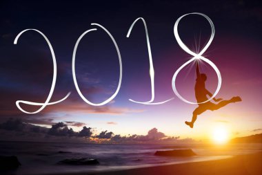 happy new year concept.young man jumping and drawing 2018  clipart