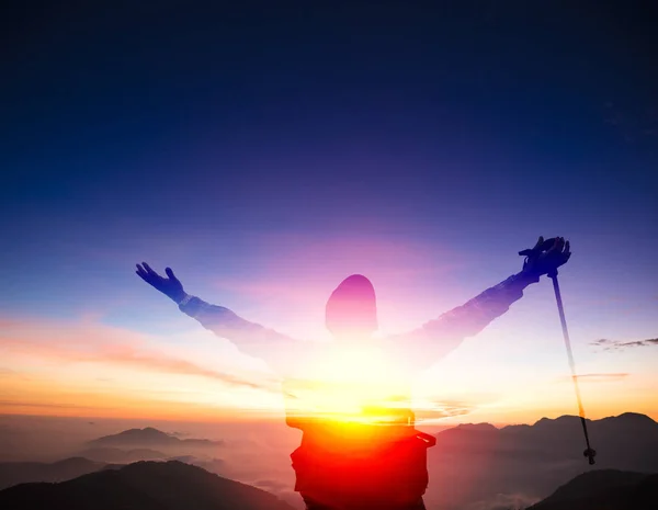 Hombre de doble exposición en la cima de la montaña observando la puesta de sol — Foto de Stock