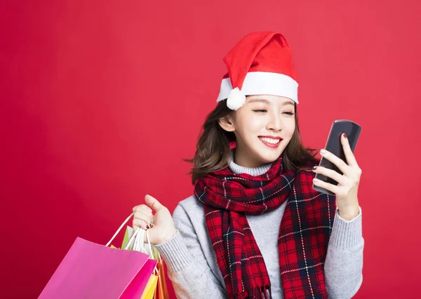 Šťastná žena nakupování vánočních dárků chytrý telefon — Stock fotografie