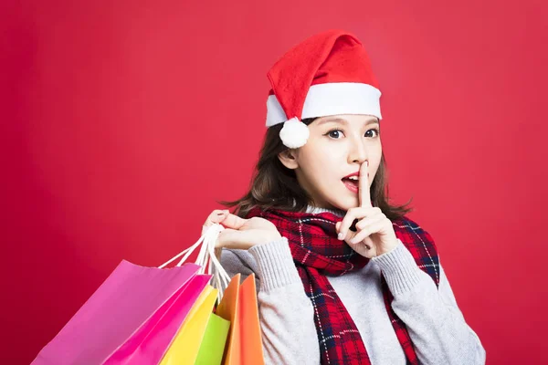 Jonge vrouw winkelen voor Kerstmis geschenken met geheime gebaar — Stockfoto