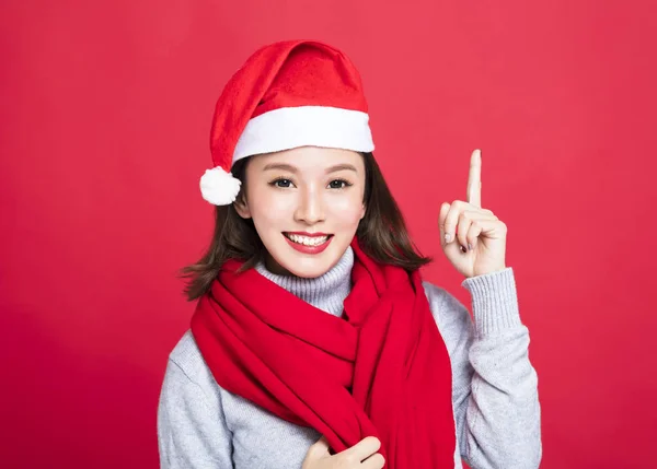 Junge Weihnachtsfrau trägt Weihnachtsmütze und zeigt nach oben — Stockfoto