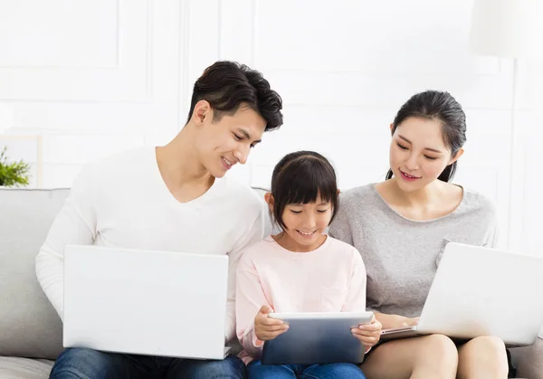 幸福的亚洲家庭与在沙发上的笔记本电脑 — 图库照片