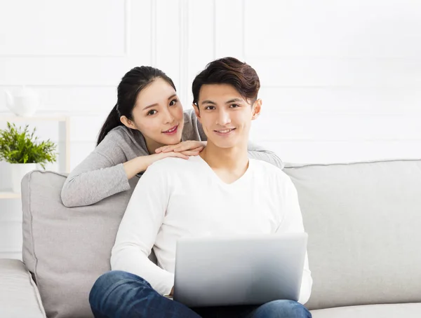 Feliz asiático pareja en sofá con laptop — Foto de Stock