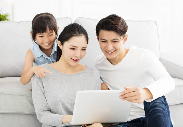 Aziatische en gelukkige familie met de laptop op de Bank — Stockfoto