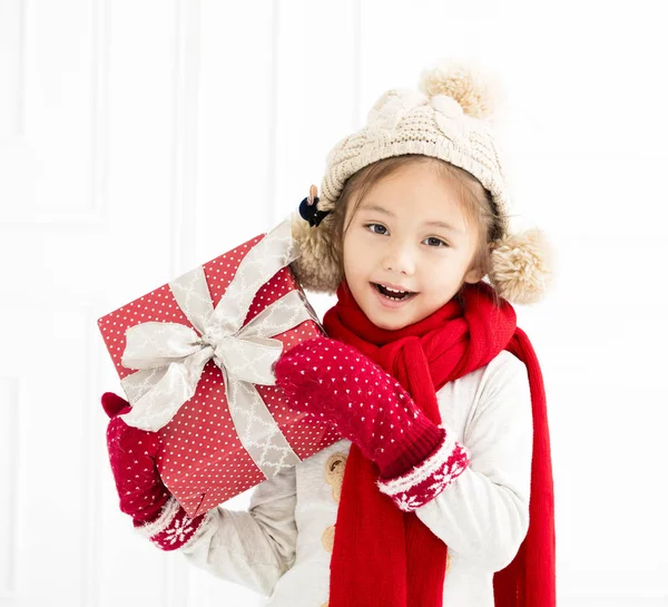 Glückliches kleines Mädchen zeigt Weihnachtsgeschenk — Stockfoto