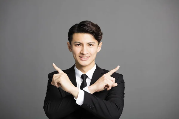 Young smiling businessman pointing to something — Stock Photo, Image