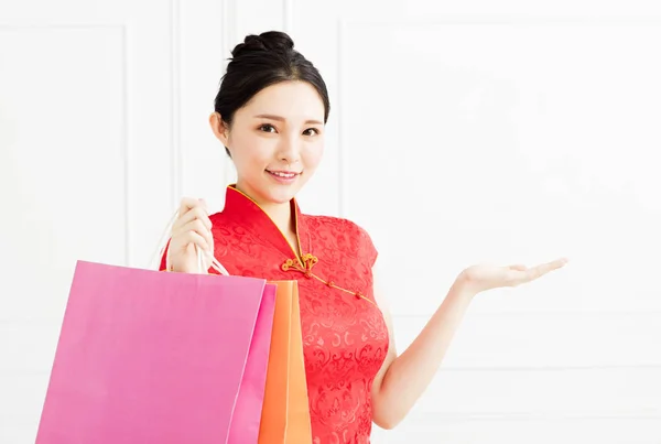 Χαμογελαστό γυναίκα δείχνει τις σακούλες ψώνια και εισήγηση για κάτι — Φωτογραφία Αρχείου