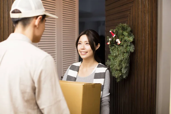 Joven mujer recibiendo paquete de entrega hombre — Foto de Stock