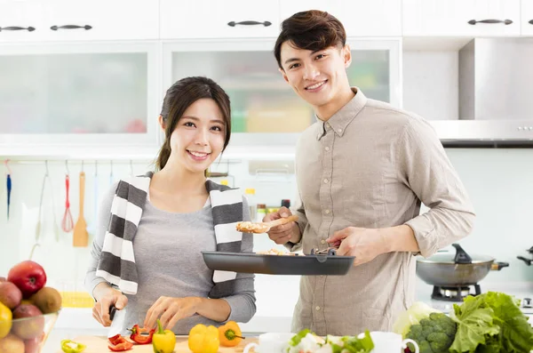 Felice giovane coppia cucina in cucina — Foto Stock