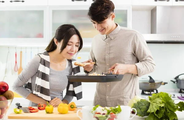台所で料理をして幸せな若いカップル — ストック写真