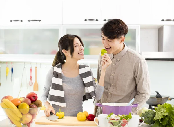 Feliz joven pareja cocina en la cocina —  Fotos de Stock