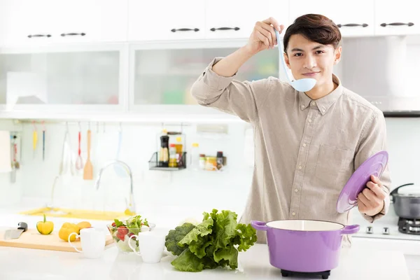 Joven cocinando en casa en la cocina —  Fotos de Stock