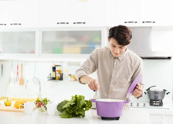 Joven cocinando en casa en la cocina —  Fotos de Stock