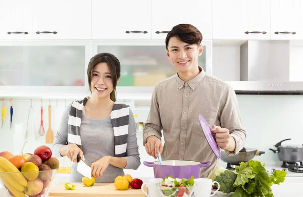 Feliz joven pareja cocina en la cocina —  Fotos de Stock