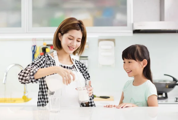 愉快的母亲和孩子在厨房喝牛奶 — 图库照片