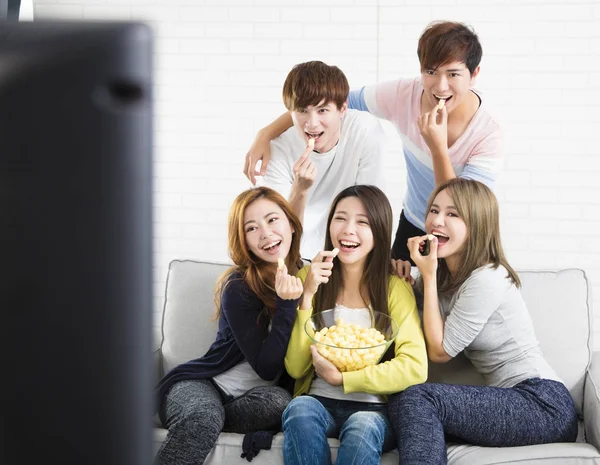 Ομάδα Νεαρών Κάθεται Στον Καναπέ Βλέποντας Τηλεόραση Δείχνουν — Φωτογραφία Αρχείου
