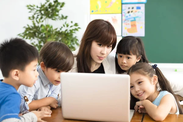 Patrząc Laptopie Nauczycielem Pobliżu Przez Dzieci — Zdjęcie stockowe