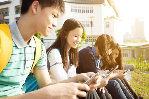 Estudiantes Adolescentes Sentados Usando Teléfono Inteligente —  Fotos de Stock