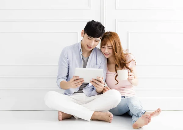 Relaxado Jovem Casal Sentado Juntos Olhando Tablet — Fotografia de Stock