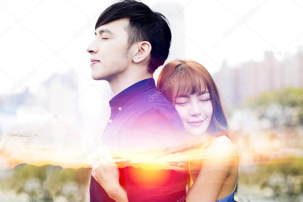 romantic young couple hugging and sunset background