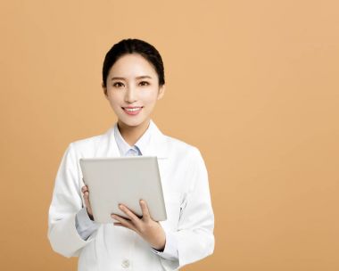 Asyalı kadın eczacı tablet ile gülümseyen