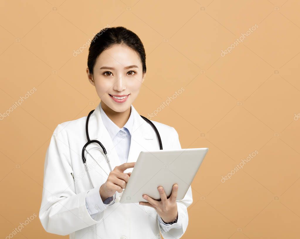 Smiling asian woman pharmacist doctor with tablet 