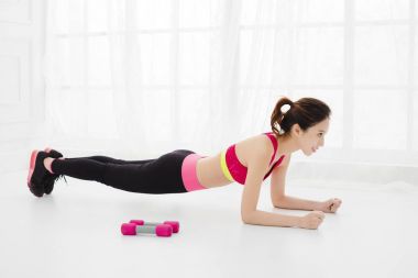 gülümseyen genç kadın evde şınav