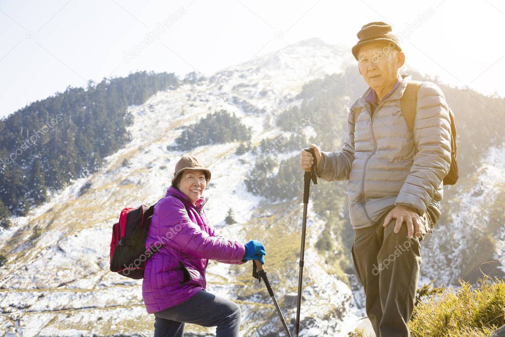 asian senior couple hiking on the mountain