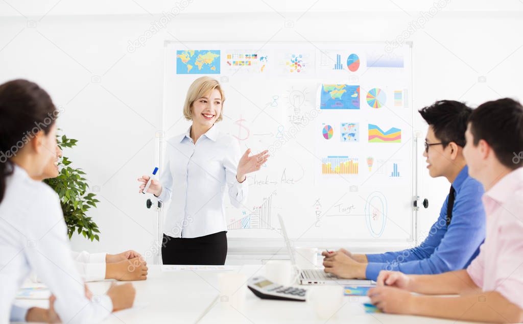 young Businesswoman presenting to colleagues at meeting