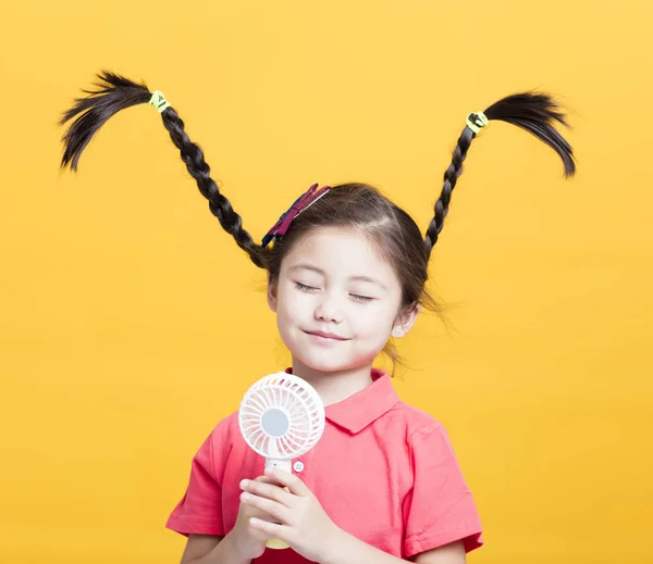 Улыбающаяся Маленькая Девочка Наслаждается Прохладным Ветром Электрического Вентилятора — стоковое фото