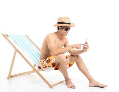 Tembel sandalyede oturan ve telefon kullanarak rahat adam