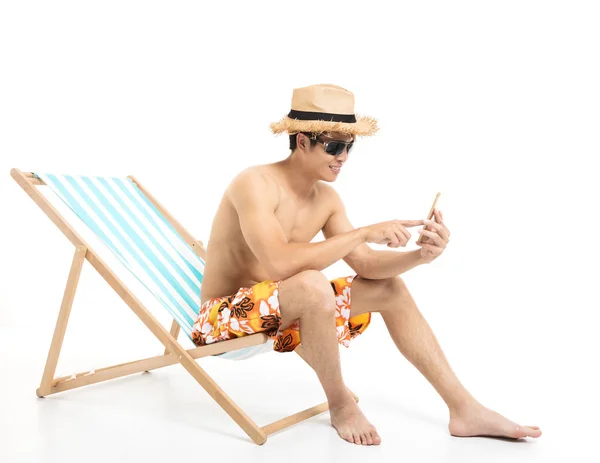 Relaxed man sitting in lounger chair and using the phone
