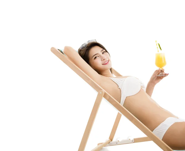 Ung kvinna i solstol med cocktail — Stockfoto