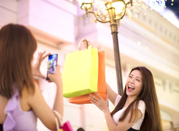 Mutlu kadın alışveriş torbaları üzerinde şehir sokak gösterilen — Stok fotoğraf
