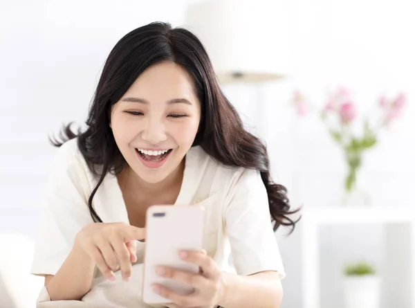 Mujer Feliz Sentada Sofá Viendo Teléfono Inteligente —  Fotos de Stock