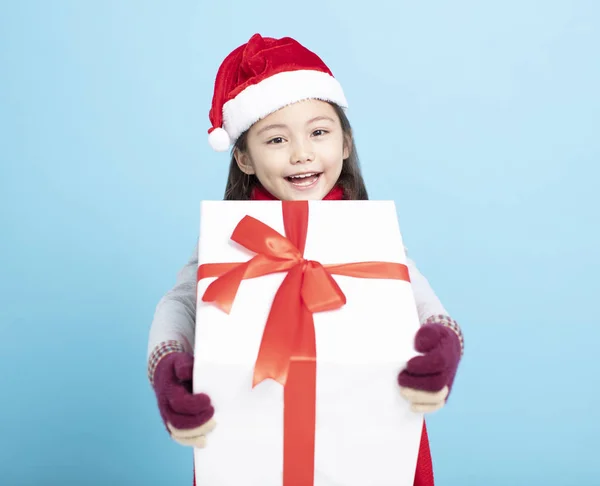 Noel Baba şapkalı mutlu küçük kız ve elinde hediye kutusu var. — Stok fotoğraf