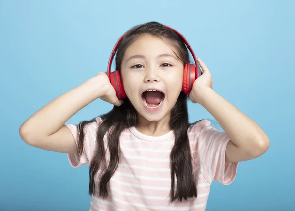 快乐的小女孩，带着耳机，一边听一边唱 — 图库照片