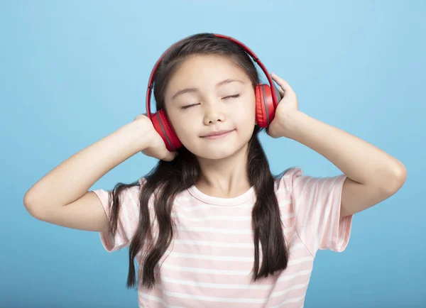 快乐的小女孩，带着耳机听音乐 — 图库照片