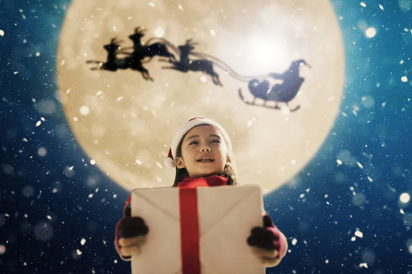 Jolie petite fille avec des cadeaux de Noël. Le Père Noël arrive en avion — Photo