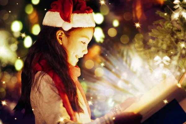 Gros plan souriant petite fille regarder les cadeaux de Noël . — Photo