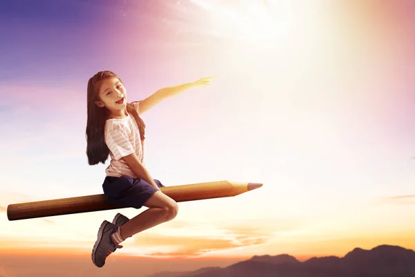 Niña feliz a lápiz y volando en el cielo — Foto de Stock