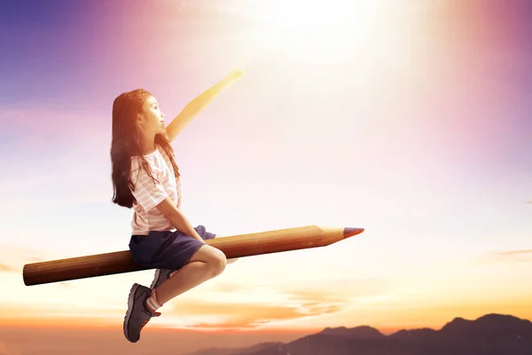 Щаслива маленька дівчинка на олівці і літає в небі — стокове фото