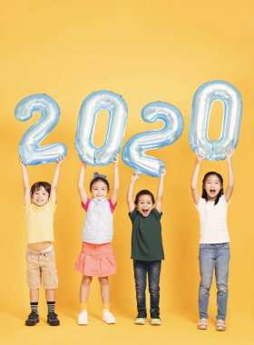 Bir grup mutlu çocuk yeni yılı kutluyor ve 2020 yılını kutluyor.