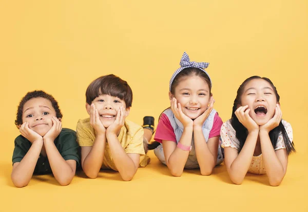 Happy children lying together  on ground — Stock Photo, Image