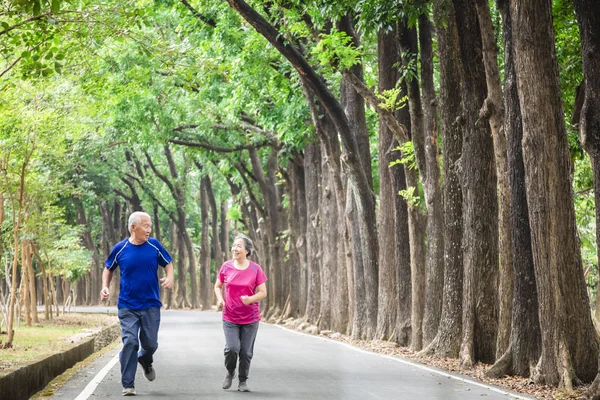 Heureux asiatique couple sénior courir à l'extérieur à parc — Photo