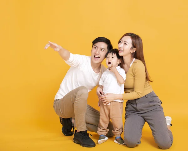 Szczęśliwa azjatycka rodzina odwraca wzrok i wskazuje — Zdjęcie stockowe
