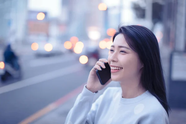 Ung kvinna gå på gatan och prata i telefon — Stockfoto