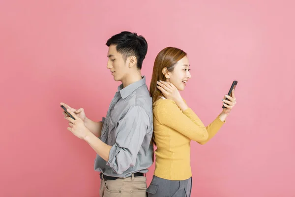 Alegre jovem casal de pé e assistindo o telefone inteligente — Fotografia de Stock