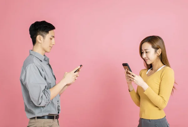 Alegre joven pareja de pie y mirando el teléfono inteligente — Foto de Stock
