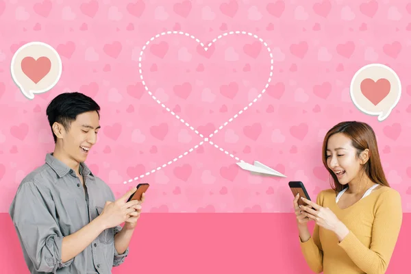 Молодая счастливая пара, использующая мобильное приложение для подключения и обмена мгновенными сообщениями — стоковое фото